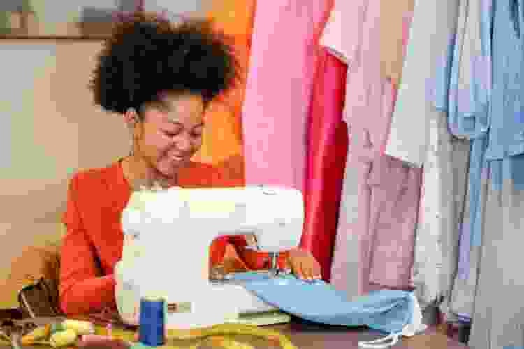 woman sewing colorful fabrics at sewing machine