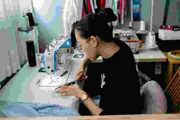 woman sewing fabrics with sewing machine