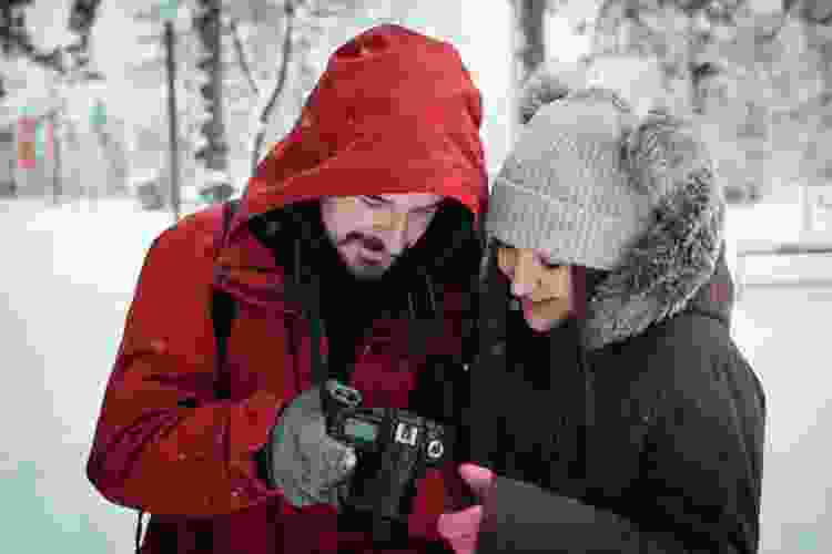 couple taking photos in the snow