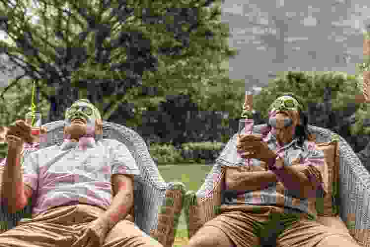 two men enjoying mud masks and cucumbers outside