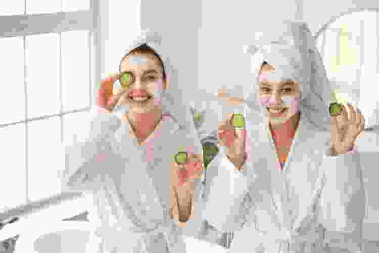 teen girls wearing mud masks and cucumbers