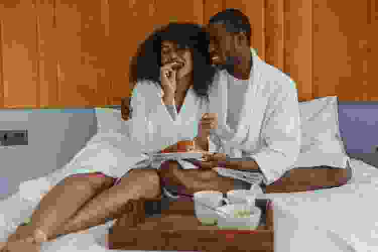 couple enjoying hotel breakfast in bed