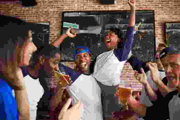 friends celebrating sports win in bar