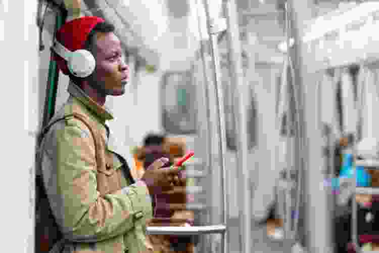 young man listening to headphones on the subway