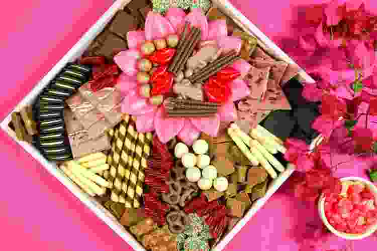 pink charcuterie board filled with chocolate and sweets