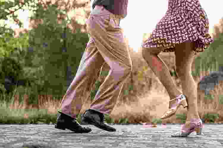 couples' feet swing dancing in the street