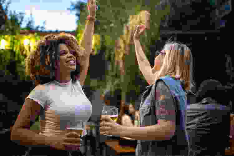 two women drinking beer at outdoor brewery