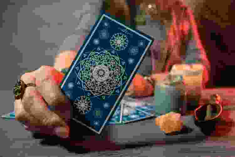 hand holding blue tarot card