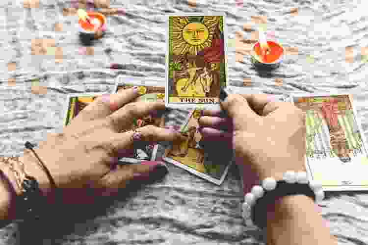 hands flipping through tarot cards