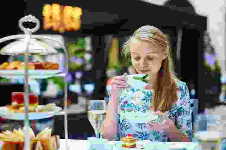 woman enjoying afternoon tea and sweets outside