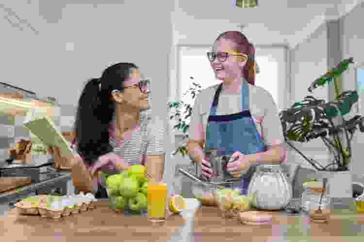 two young teens baking cookies 