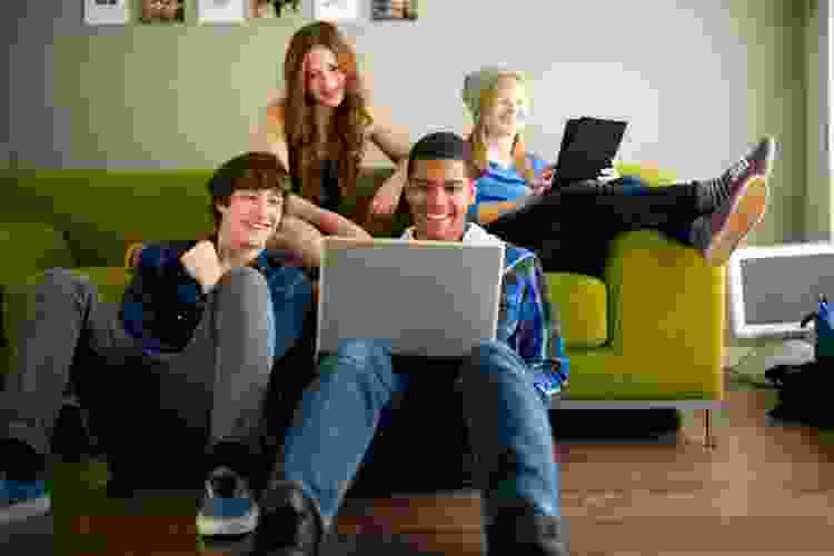 group of teens playing games on laptop