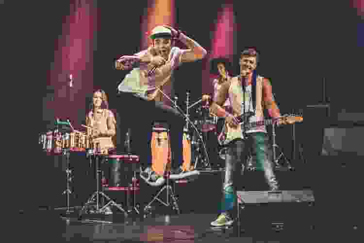 group of teens playing as a band on stage in talent show