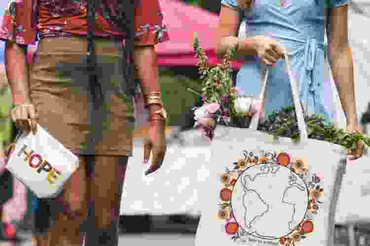 young woman carrying printed tote bags