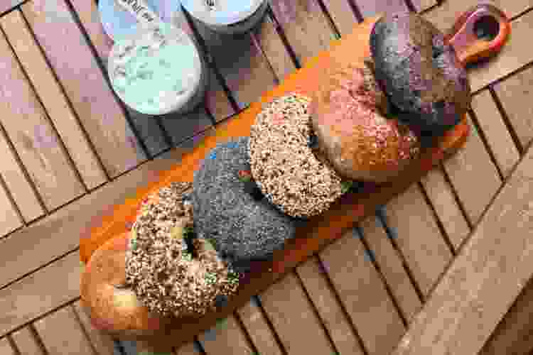 line of differently seasoned bagels on serving board