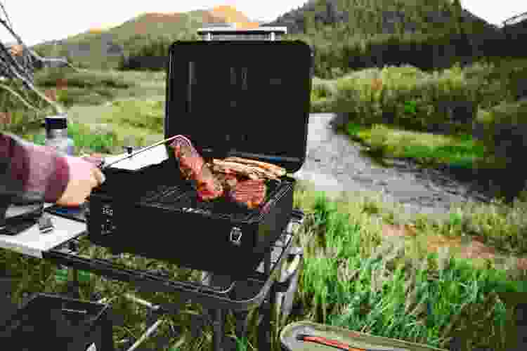 portable Traeger grill with steaks overlooking mountains