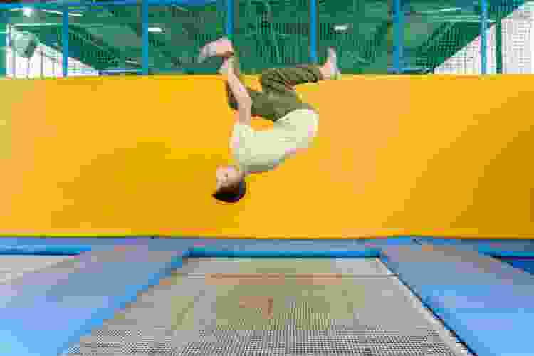 kid doing a flip at an indoor trampoline park