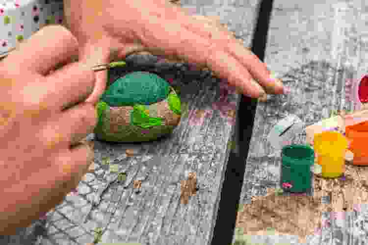painting green sea turtle on small rock