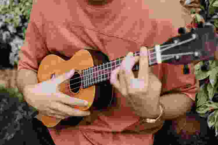 close-up of man strumming ukulele