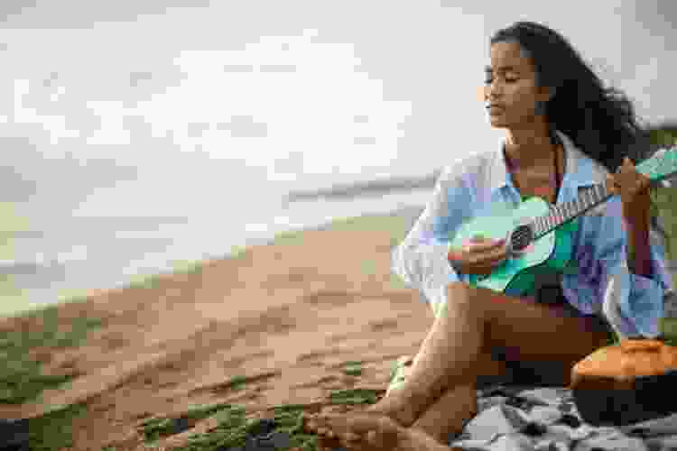 woman playing ukulele on the beach