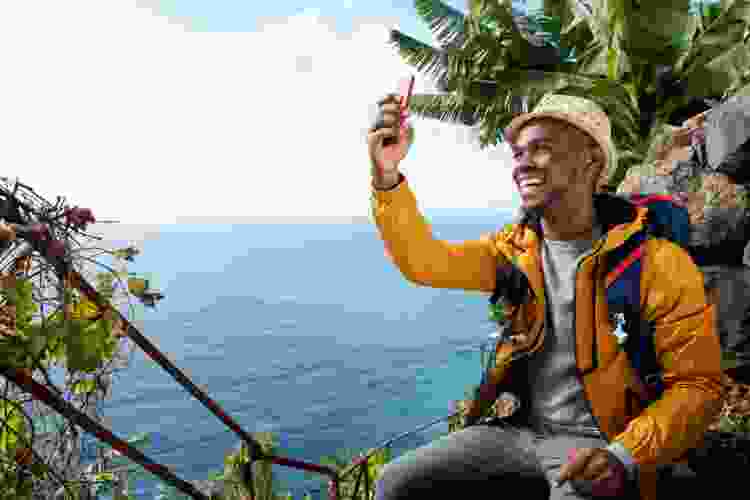 young man taking selfie on beach vacation