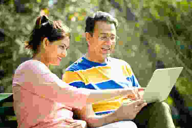 adult couple playing game on computer outdoors