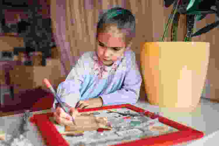 young girl making art vision board collage