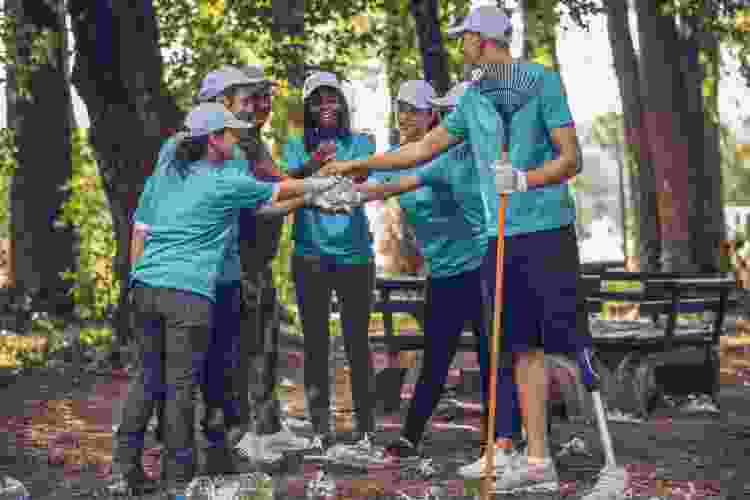 group of friends high fiving after picking up trash as volunteers