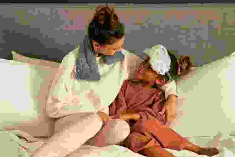 mother and daughter in bed wearing Warmies heated slippers and wraps