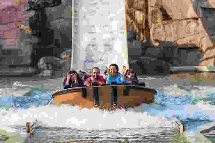 family smiling on water ride at theme park