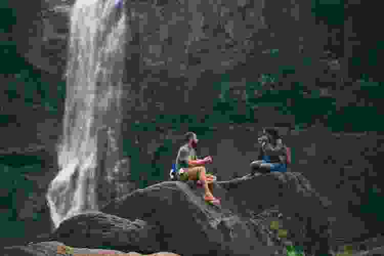 couple on rocks near waterfall