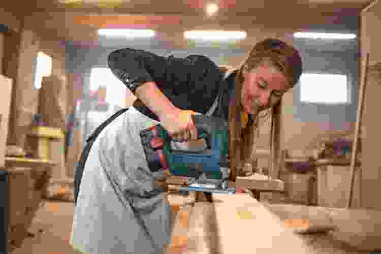 woman sawing in woodshop