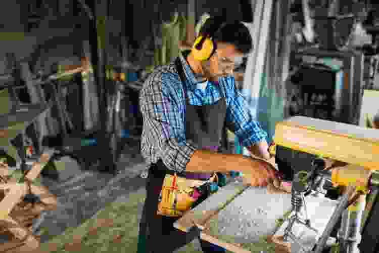 man sawing wood in wood shop