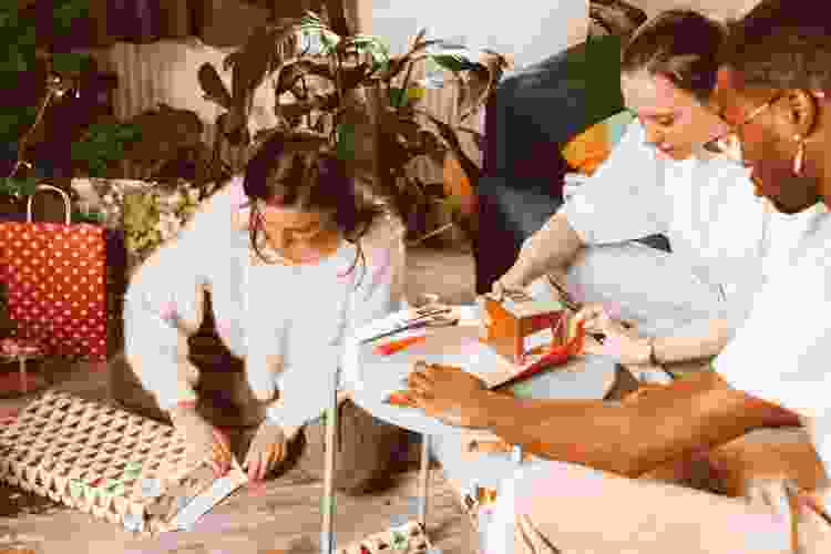 group of friends wrapping Christmas gifts together