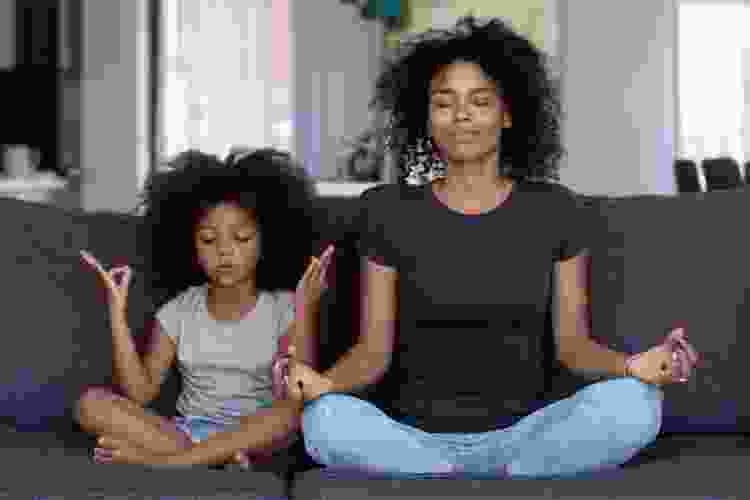 mother and daughter sitting in yoga position meditating