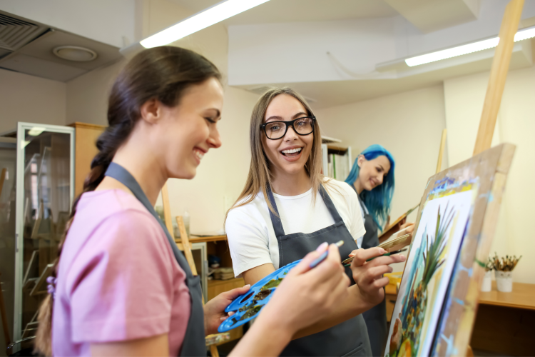 two young women in paint and sip