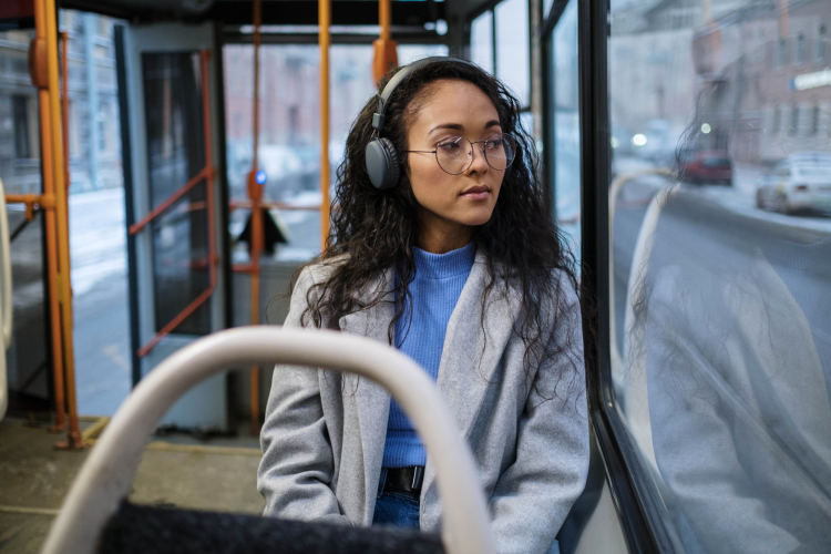 woman wearing headphones on tram