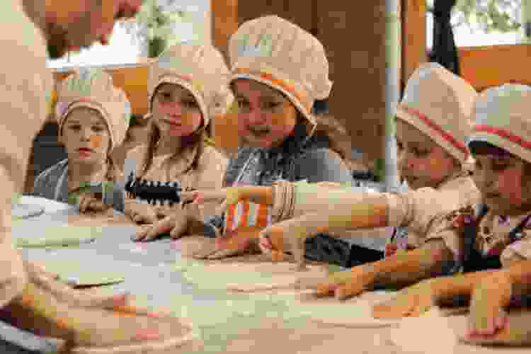 Kids learning to make pizza