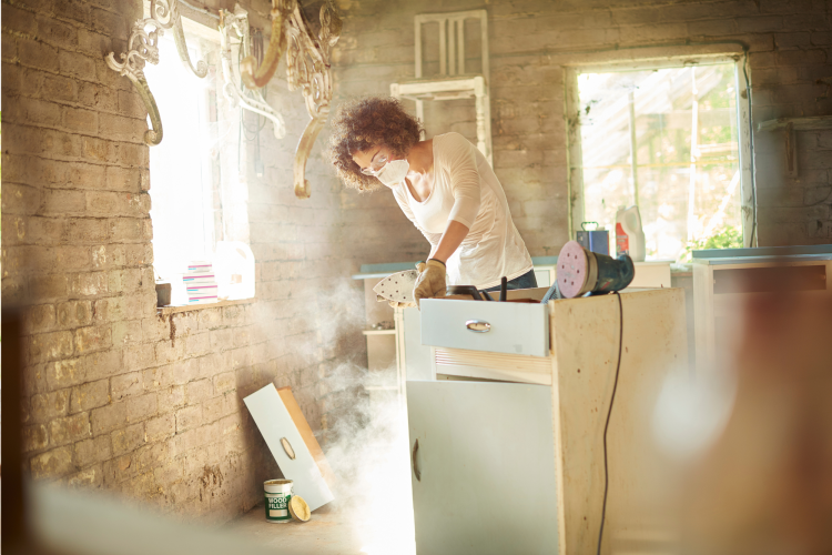 Woman working on restoring a wooden cabinet