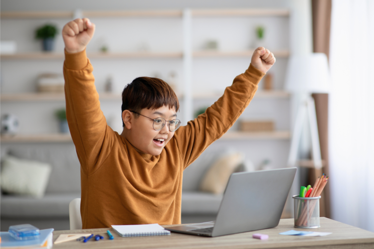 boy at the computer cheering