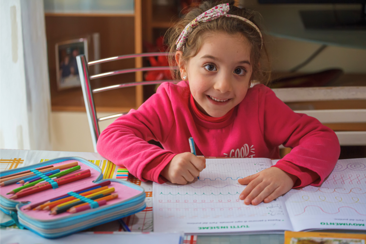 Child smiling while doing homework