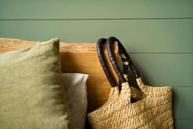 bench with a pillow and woven bag