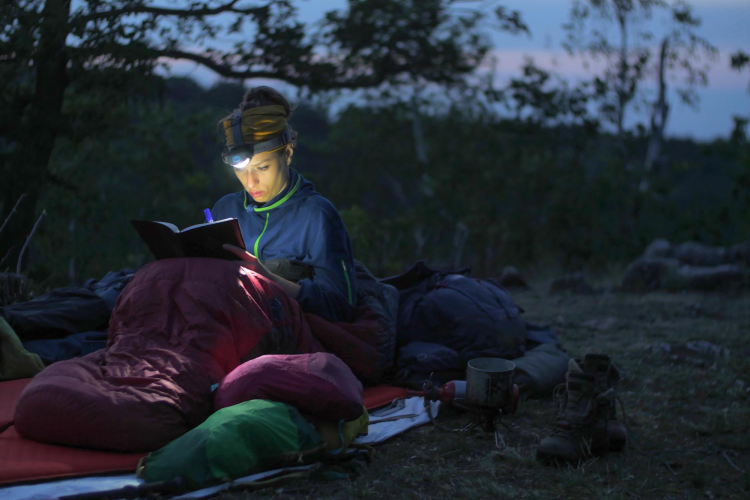 Woman Camping with Headtorch Reading