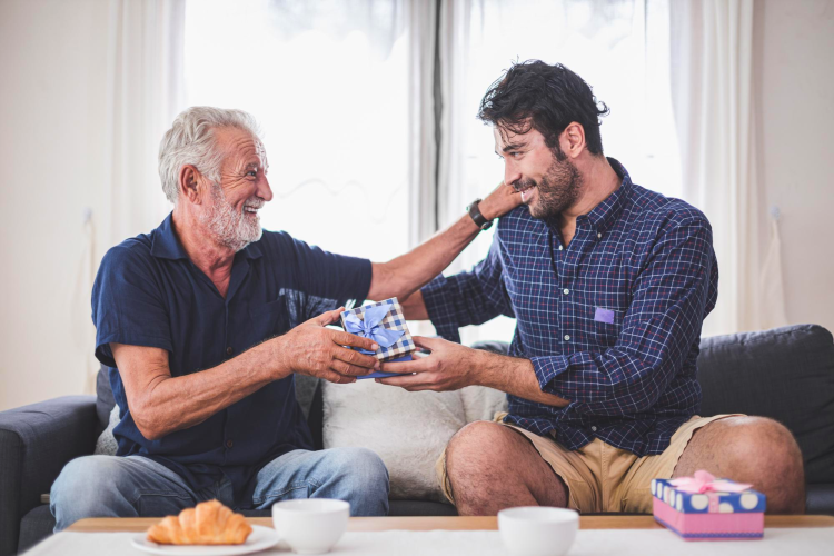 Adult Son giving father's day greeting and gift
