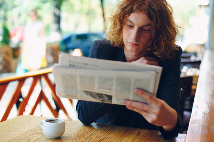 young man reading newspaper
