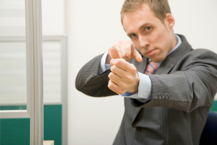 man in a suit shooting a rubber band