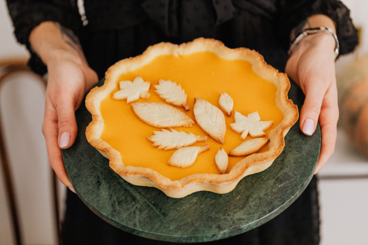 Person holding pumpkin pie for halloween party theme