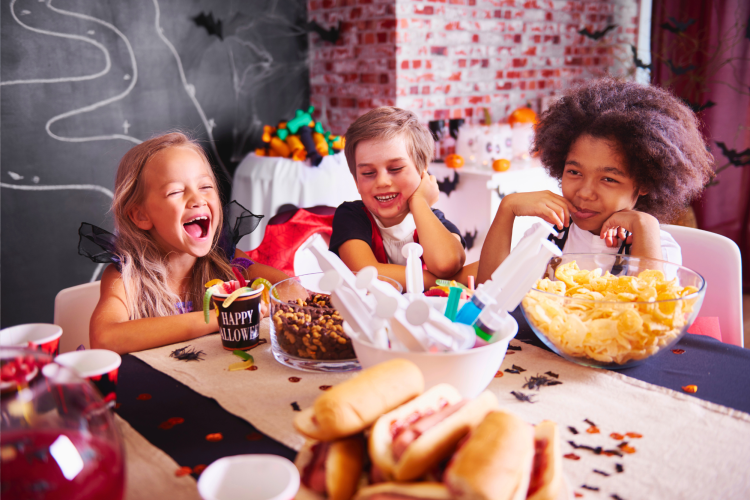 diverse kids laughing and eating candy during Halloween
