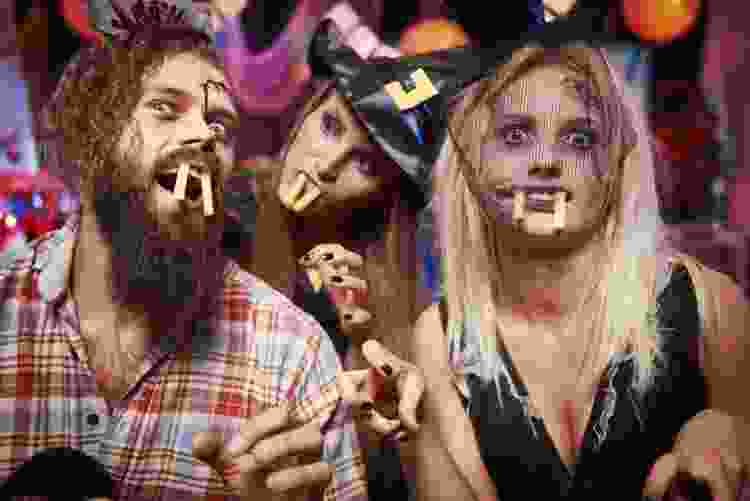 young friends having fun halloween party silly