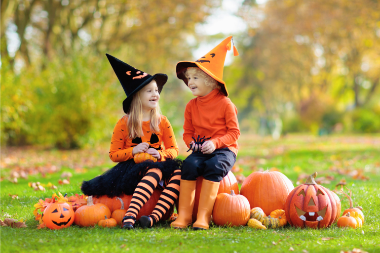 kids laughing while sitting on pumpkins